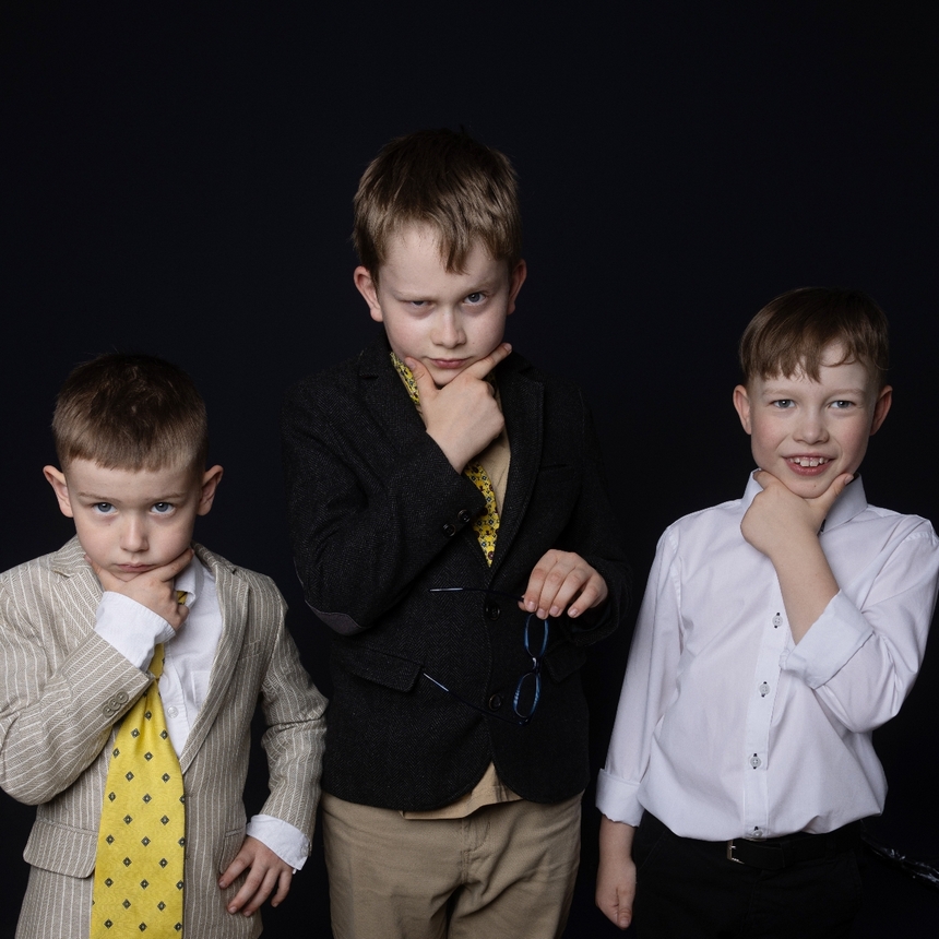 trzech chłopców patrzy w zamyśleniu